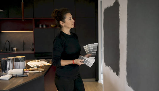 Woman comparing paint samples in living room