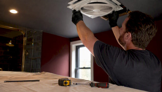 Technician installing bathroom exhaust fan