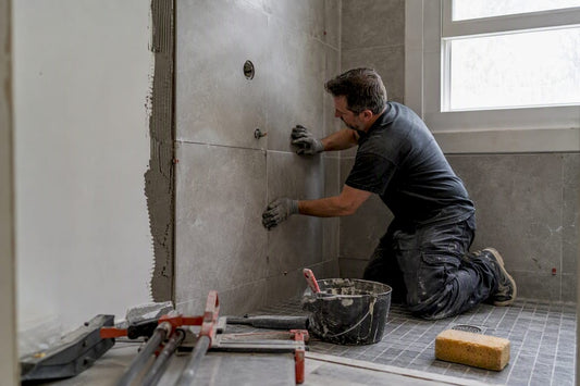 Worker applying waterproofing membrane in shower alcove