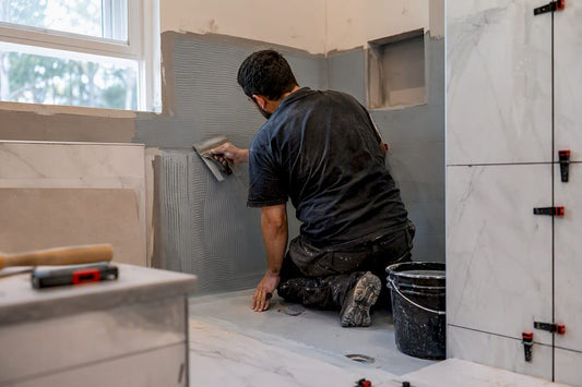 Installer applying waterproofing membrane in shower