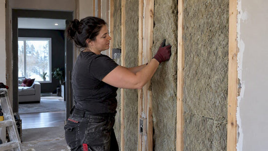 Contractor installing acoustic wall insulation
